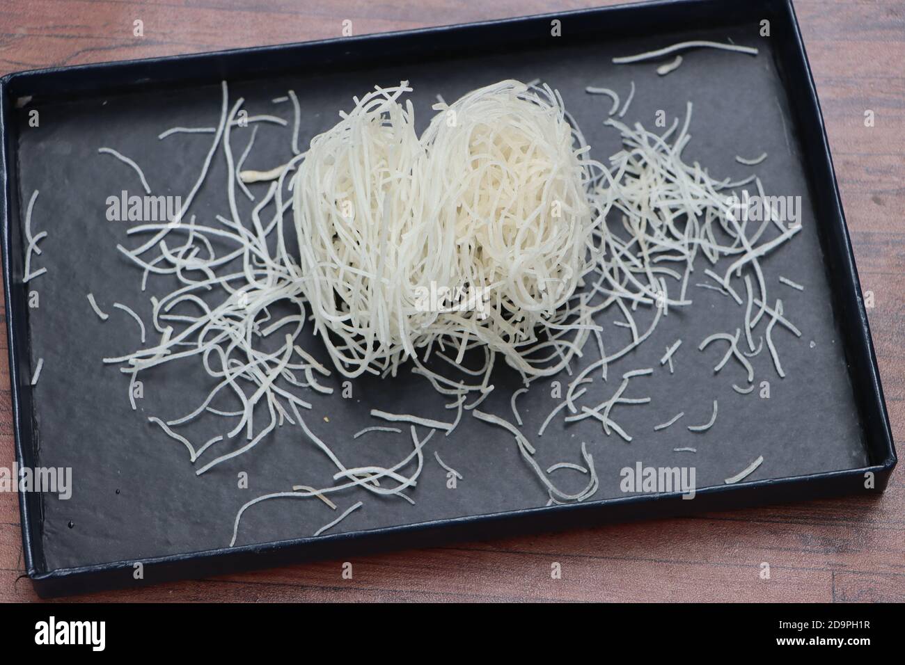 Tagliatelle di riso o pasta o veemicelli su fondo nero Foto Stock