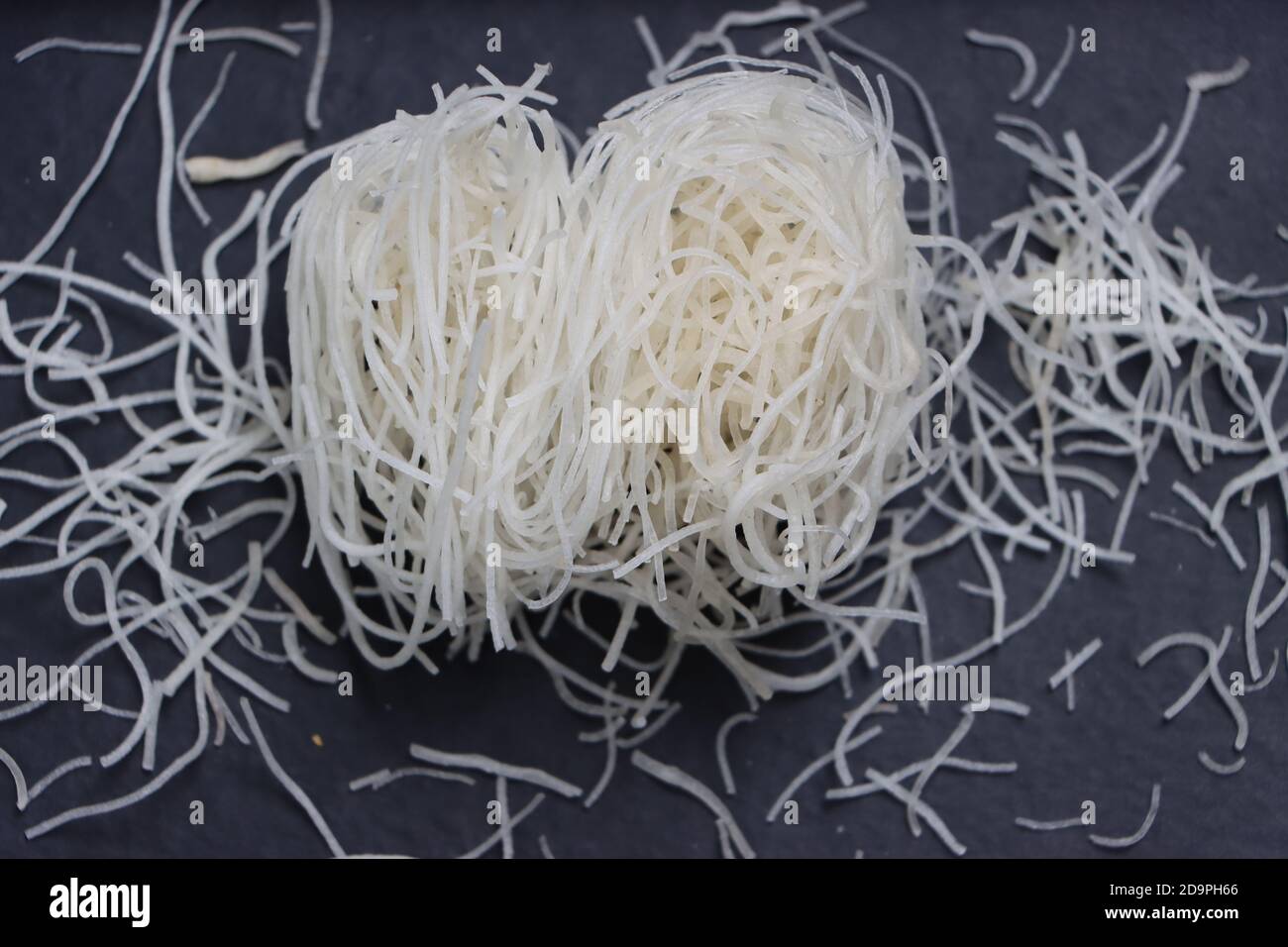 Tagliatelle di riso o pasta o veemicelli su fondo nero Foto Stock