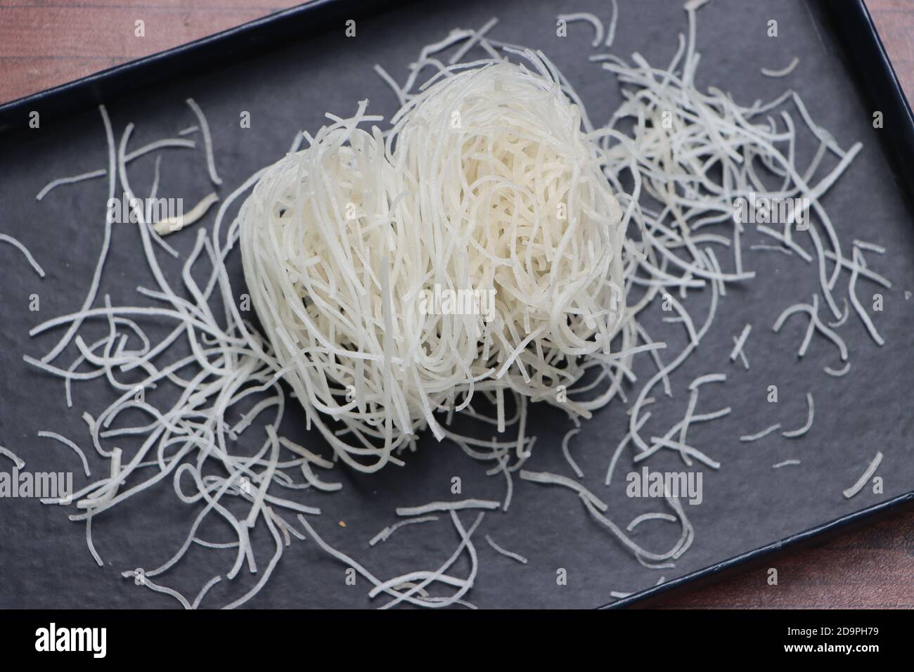 Tagliatelle di riso o pasta o veemicelli su fondo nero Foto Stock