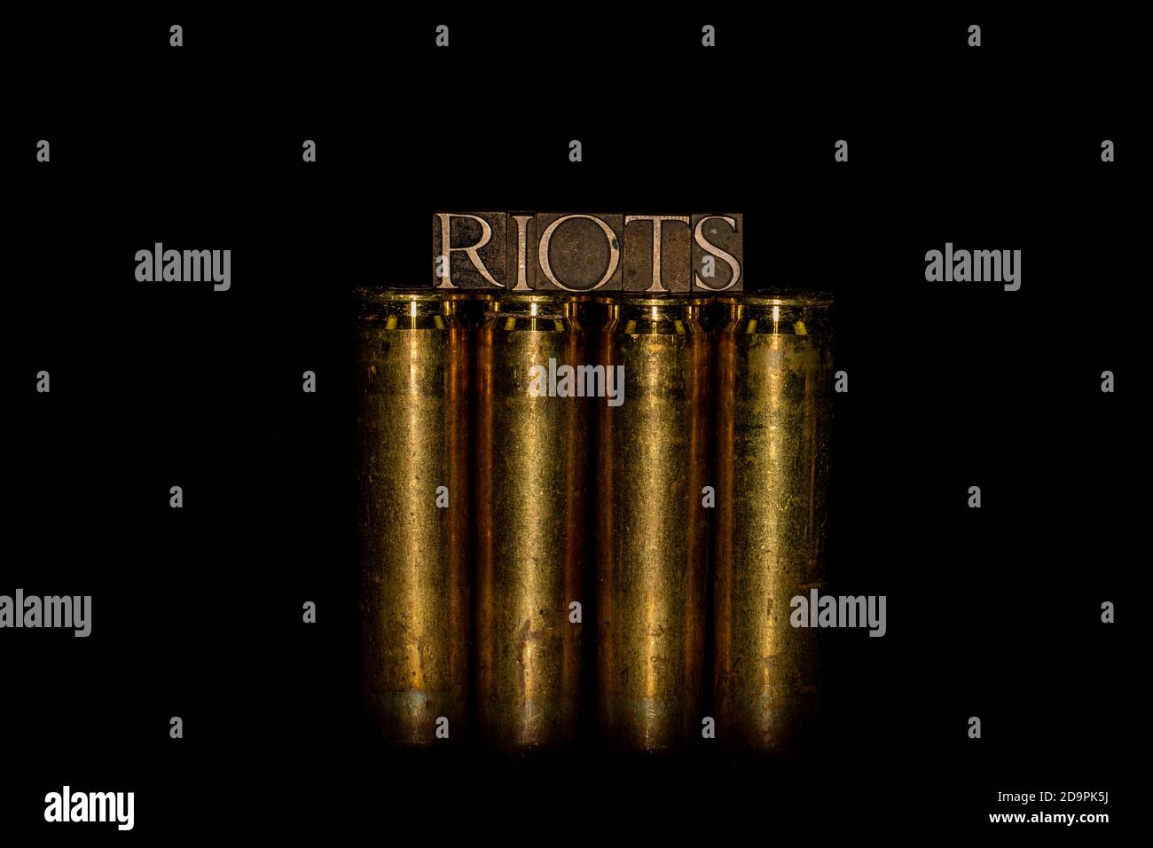 Testo di riots formato con le lettere autentiche autentiche autentiche del typeset su 50 Caliber BMG bullet con sfondo nero Foto Stock