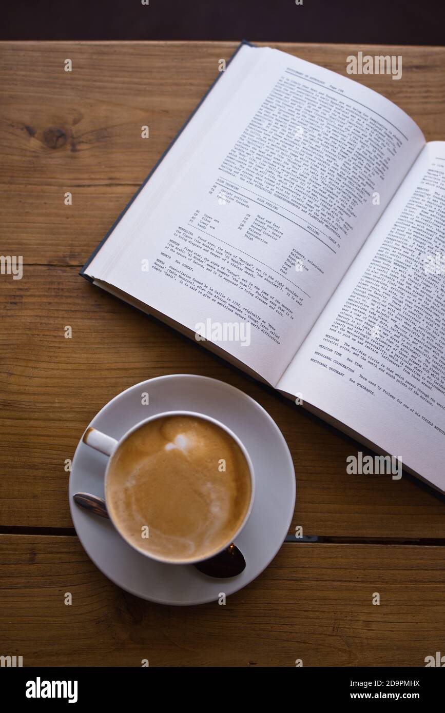 Caffè bianco piatto con libro nella caffetteria sul tavolo - Coffee art - caffè latte Foto Stock