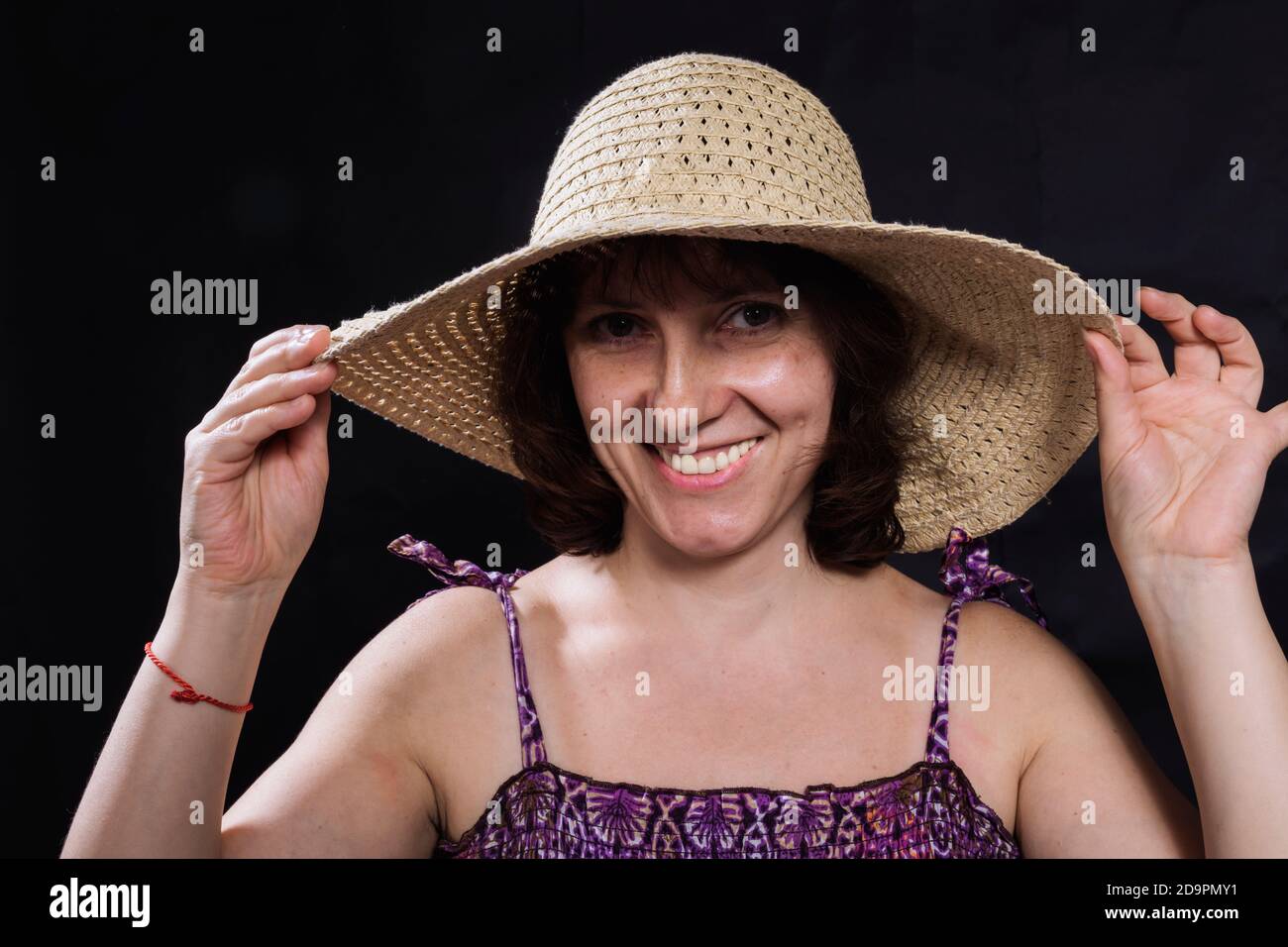 Allegra donna di 40 anni in un cappello largo-brimmed primo piano visualizza ritratto studio Foto Stock