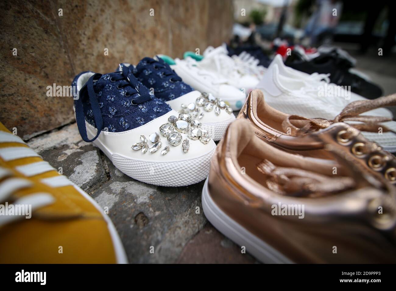 Bucarest, Romania - 17 maggio 2019: Immagine della profondità di campo (fuoco selettivo) poco profonda con vari tipi di sneakers femminili sul marciapiede come una forma di pr Foto Stock
