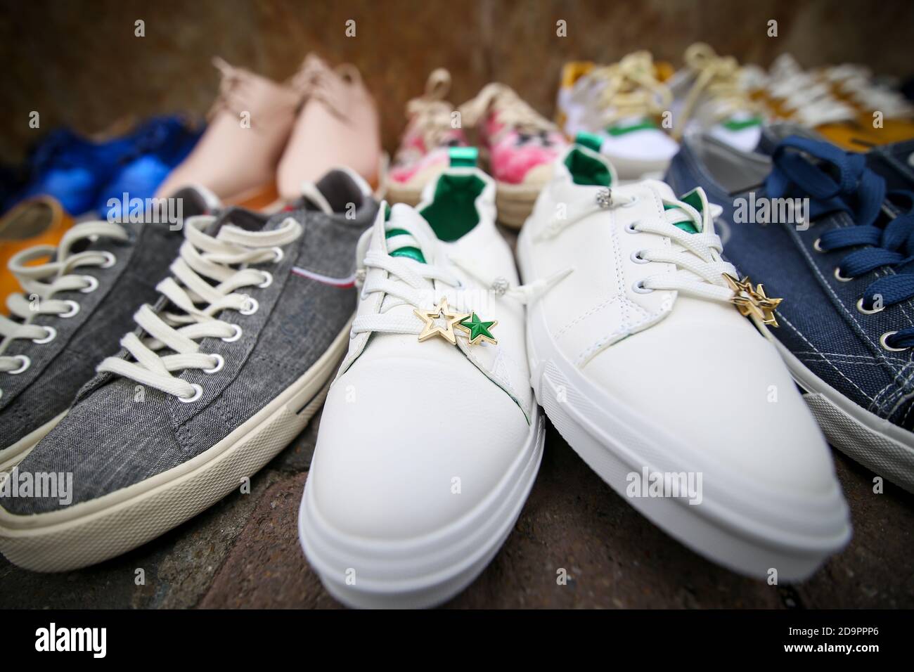 Bucarest, Romania - 17 maggio 2019: Immagine della profondità di campo (fuoco selettivo) poco profonda con vari tipi di sneakers femminili sul marciapiede come una forma di pr Foto Stock