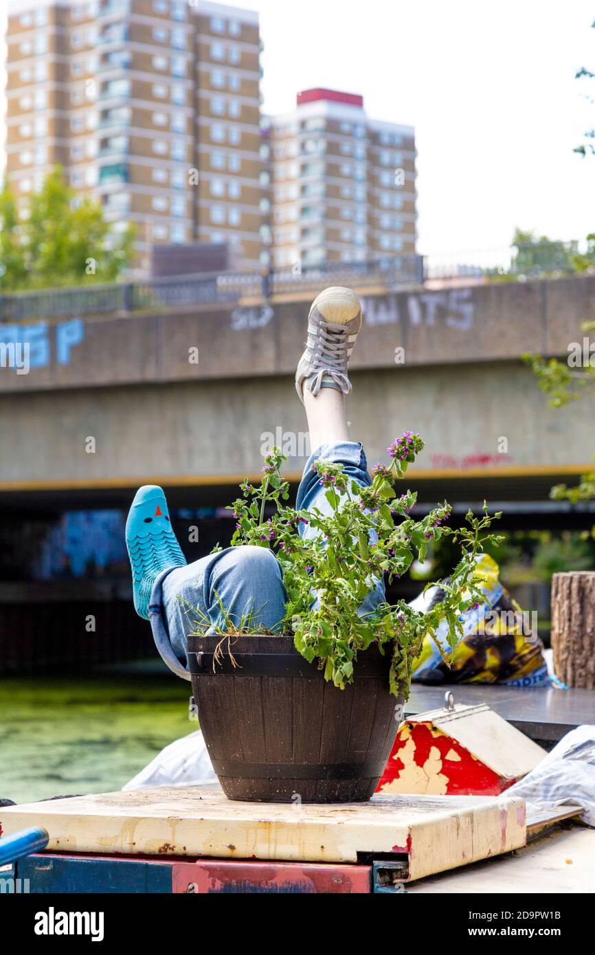 Insolita decorazione chiatta con gambe che si stacca da una piantatrice lungo Hertford Union Canal a East London, UK Foto Stock