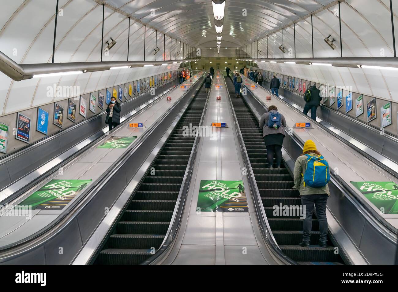 LONDRA, INGHILTERRA - 23 OTTOBRE 2020: Scale mobili della metropolitana di Londra alla stazione di Holborn durante l'ora di punta, spostarsi con i passeggeri che indossano maschere facciali Foto Stock