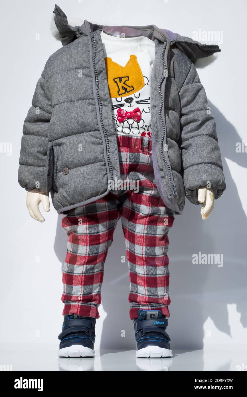 Kharkiv, Ucraina, 26 settembre 2020: Manichino per bambini nella finestra di un negozio di abbigliamento per bambini, boutique. Moda aspetto autunno: Pantaloni in una gabbia, un testo Foto Stock