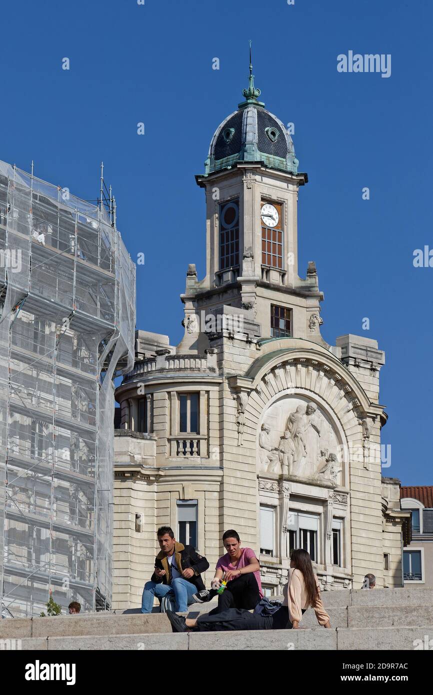 LIONE, FRANCIA, 31 marzo 2019 : seduto sulle scale del fiume Rodano con il Palais de la Mutualité sullo sfondo. Foto Stock