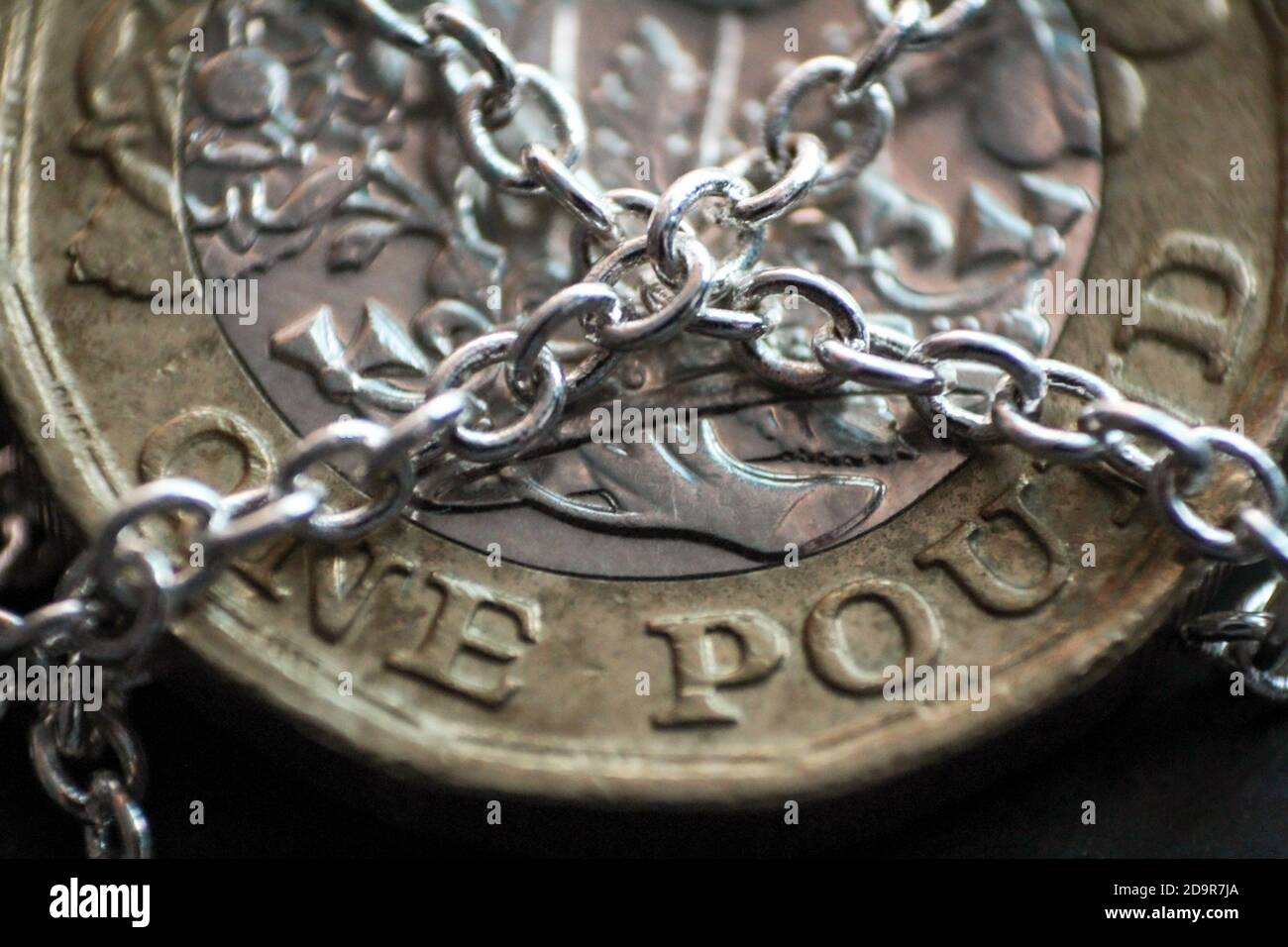 Macro primo piano di una nuova moneta britannica da una libbra con catene su di essa, concetto di sicurezza finanziaria. Foto Stock