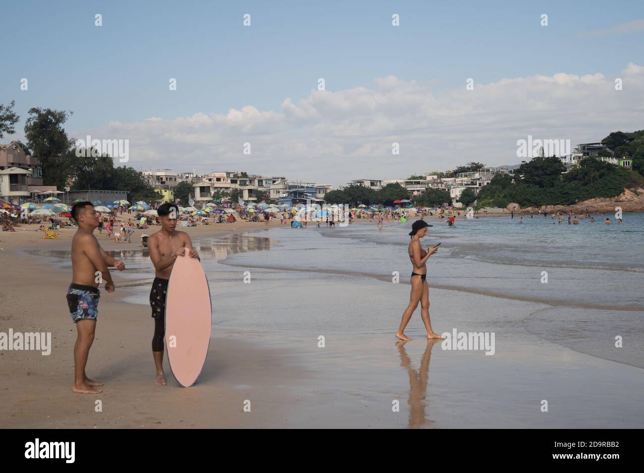 Un uomo visto con la sua tavola da surf a Shek o spiaggia nel primo fine settimana dopo la riapertura delle spiagge pubbliche.mentre l'epidemia di Coronavirus Covid-19 a Hong Kong rallenta, il governo ha annunciato la riapertura delle spiagge pubbliche. Le spiagge pubbliche di Hong Kong sono state chiuse dal luglio 2020 come misura preventiva stabilita dal governo per combattere l'epidemia del Coronavirus Covid-19. Foto Stock