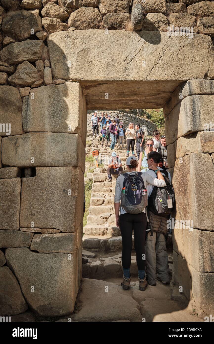 Una posa di coppia per un ritratto di foto in una porta alle rovine di Machu Picchu, Perù Foto Stock