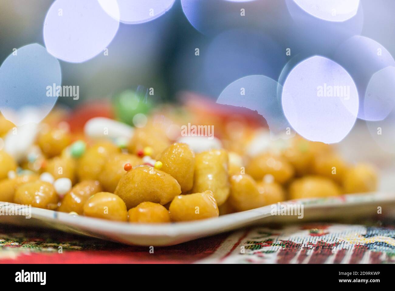 Struffoli italiani dolci fatti in casa, polpette fritte e immerse nel miele con Sprinkles. Tipico dessert napoletano delle feste natalizie. Foto Stock