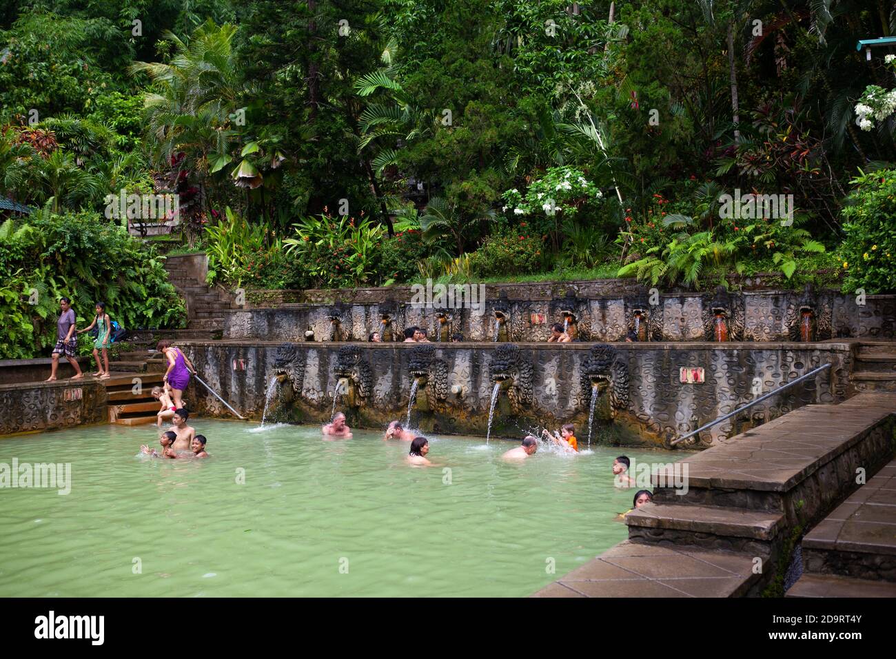 Banjar, Bali / Indonesia - Marzo 08 2013: Locali e visitatori internazionali che prendono la doccia sotto la famosa acqua solforica nel secolare Banjar Hot Foto Stock