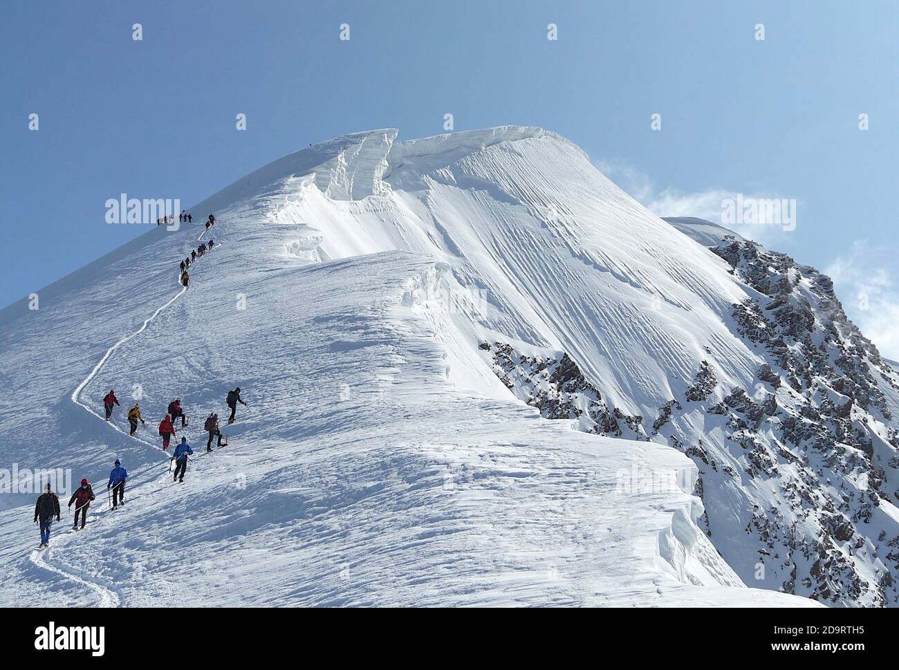 Alpinisti arrampicate sul pendio innevato della cima Strahlhorn in Svizzera Alpi Foto Stock