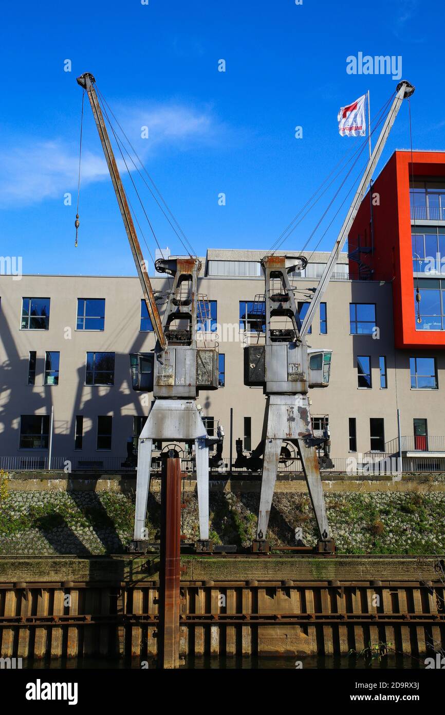 Neuss, Germania - Novembre 11. 2020: Vista sulle vecchie gru storiche al molo di sbarco del porto di carico interno sul fiume reno Foto Stock