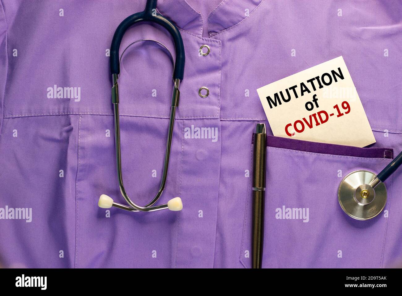 Uniforme medica, cartoncino bianco con mutazione di parole COVID-19, penna metallica e stetoscopio. Concetto di pandemia medica e COVID-19. Foto Stock