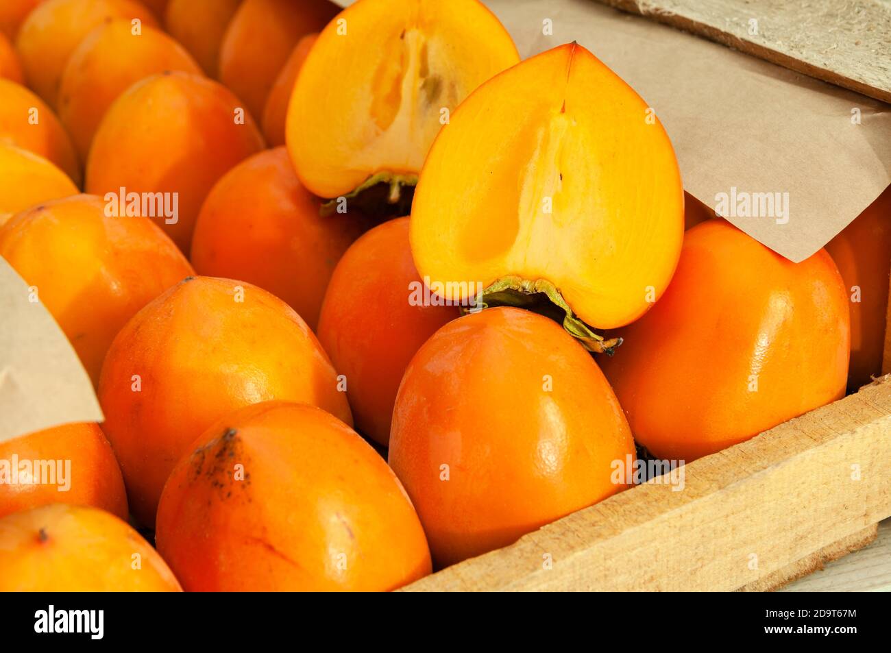 Persimmons freschi biologici maturi in una scatola di legno prima della spedizione al mercato. Foto Stock