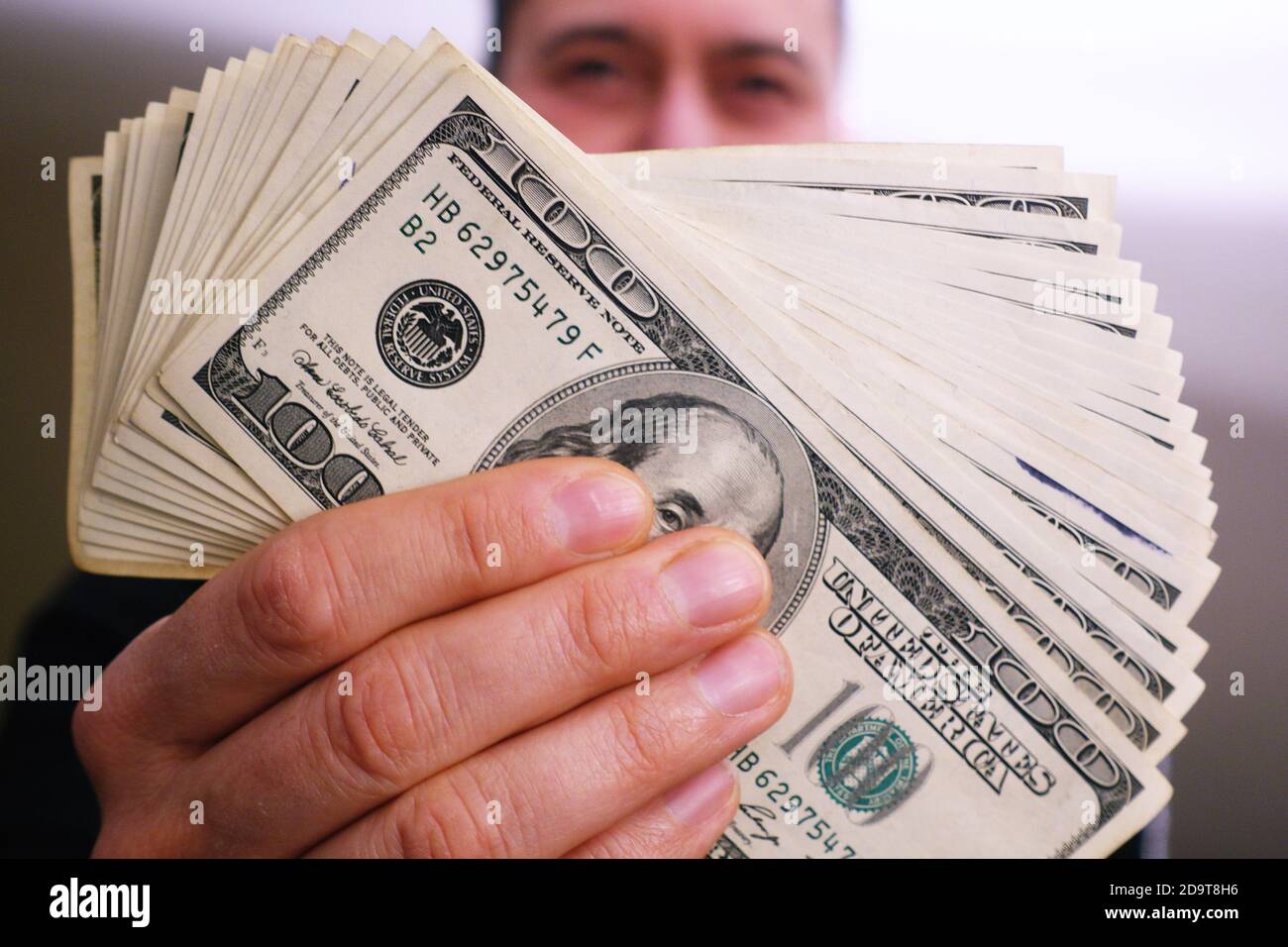 Un mucchio di 100 dollari fatture in un uomo ricco mani Foto Stock