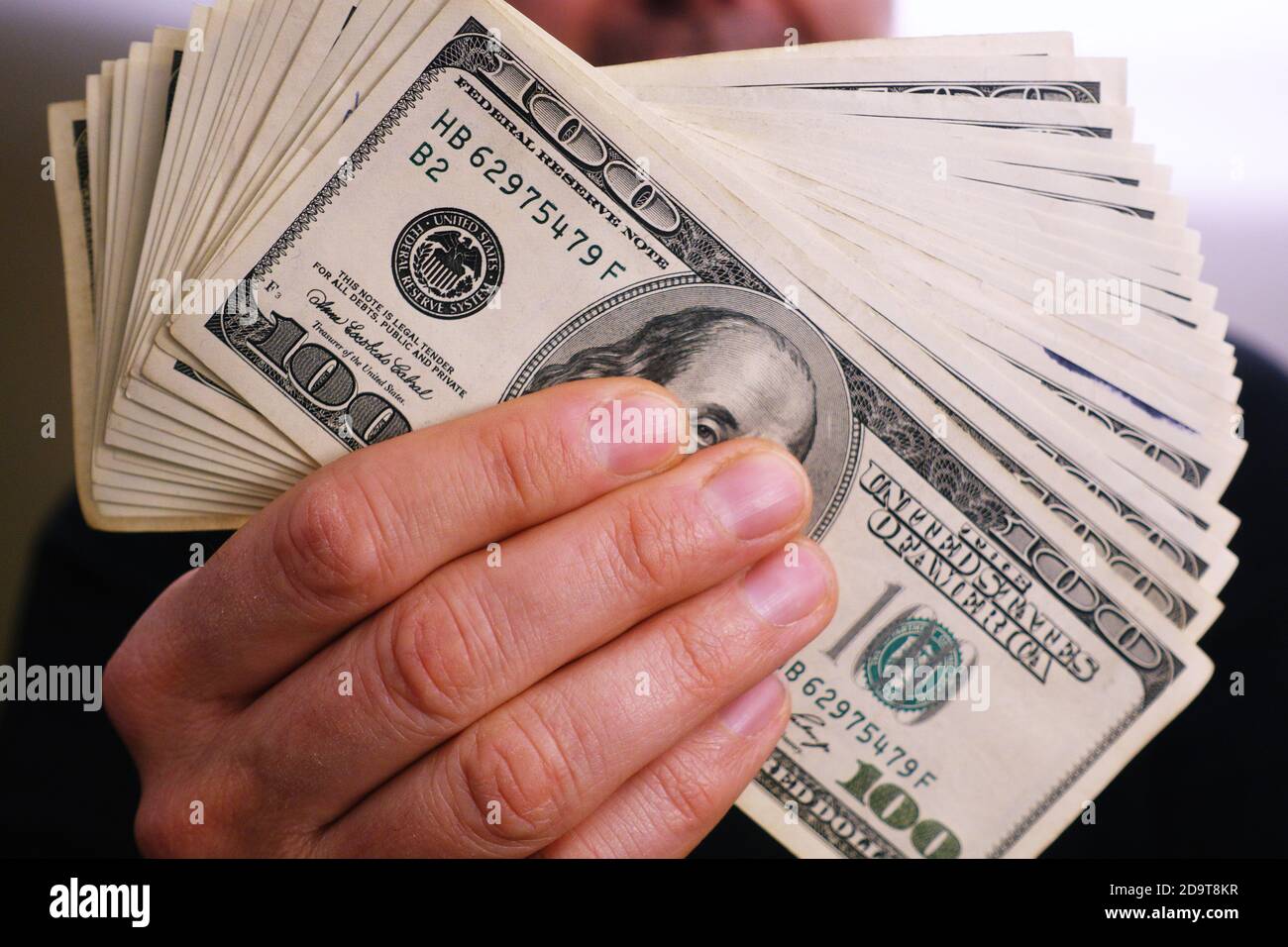 Un mucchio di 100 dollari fatture in un uomo ricco mani Foto Stock