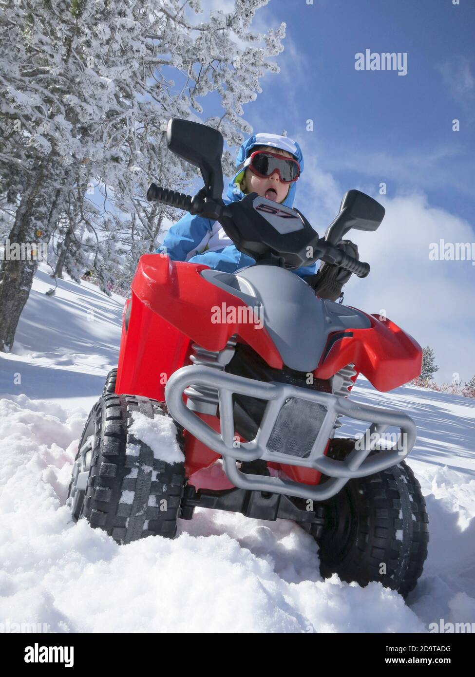 Avventuriero audace su un quad giocattolo in un paesaggio innevato In una località invernale nei Pirenei Foto Stock