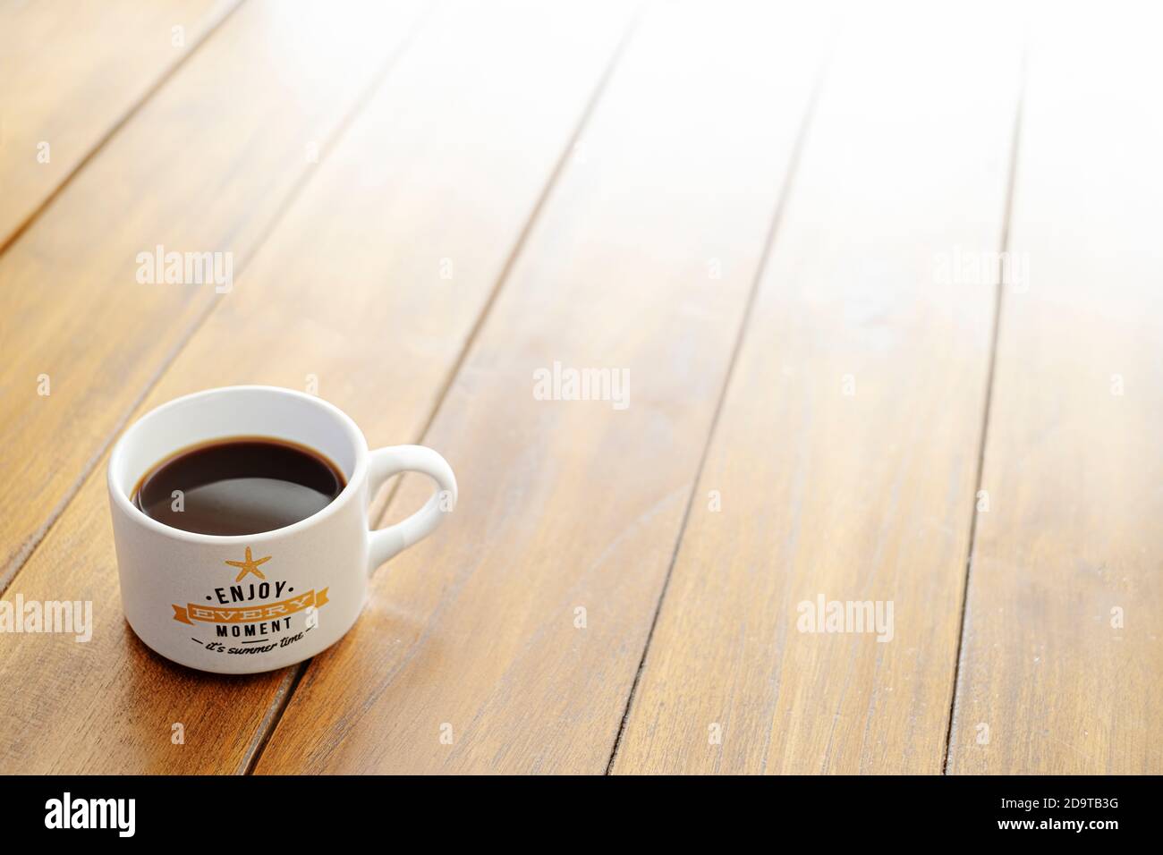 tazza di caffè su un tavolo di legno con un messaggio di godetevi ogni momento è estate sfondo Foto Stock