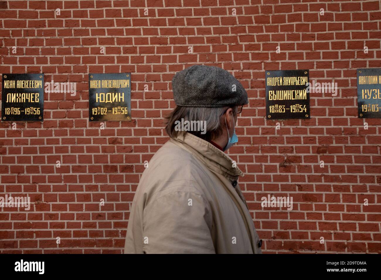 Mosca, Russia. 7 novembre 2020 UN uomo guarda le bandiere con i nomi della politica sovietica al Muro del Cremlino, dove i leader di stato sovietici sono sepolti, nel centro di Mosca, Russia Foto Stock