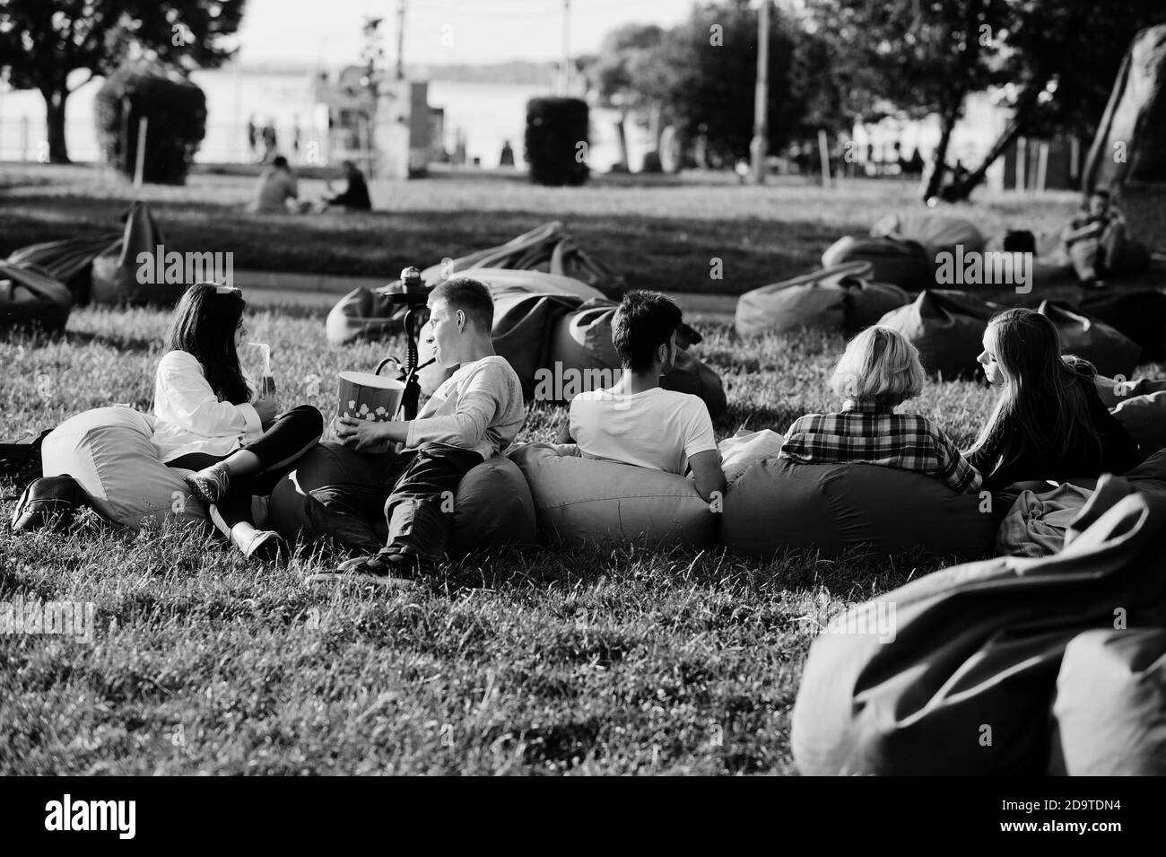 Gruppo giovane multietnico di persone che guardano film al poof nel cinema all'aperto. Foto Stock