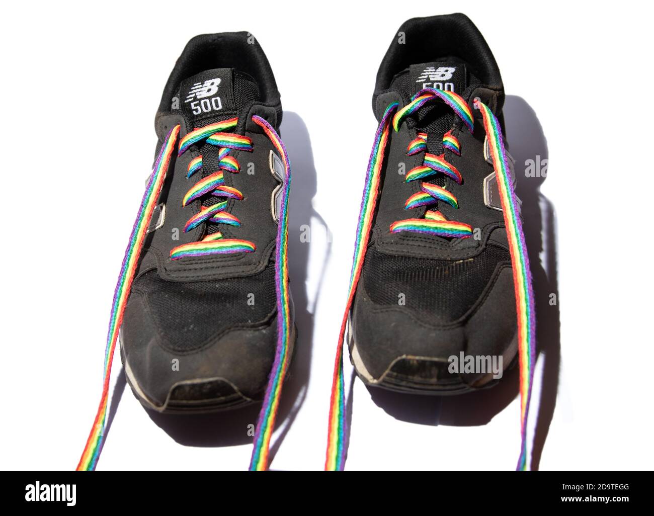 Un paio di formatori Black New Balance 500 con Stonewall Lacci arcobaleno LGBT Foto Stock