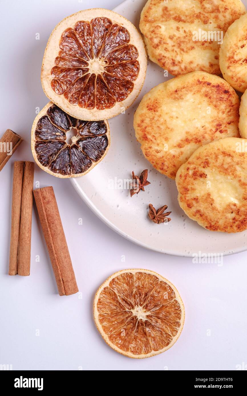 Frittelle di formaggio di cottage. Colazione di Natale con anice e cannella su sfondo bianco, vista dall'alto Foto Stock