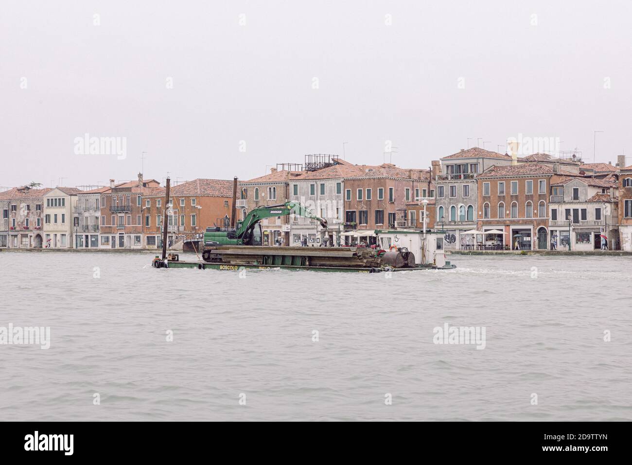 Trasporto in barca speciale a Venezia, barca che trasporta un escavatore attraverso il canale Giudecca a Venezia Foto Stock