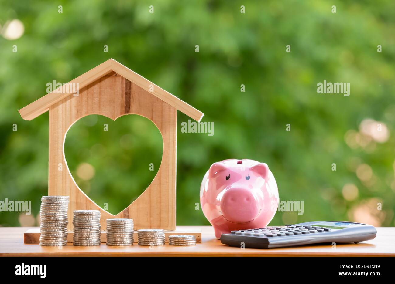 Happy Pink Piggy Bank e Home legno in primo piano e monete stack in natura sfondo, risparmio idee e budget di investimento, Business risparmiare denaro Foto Stock