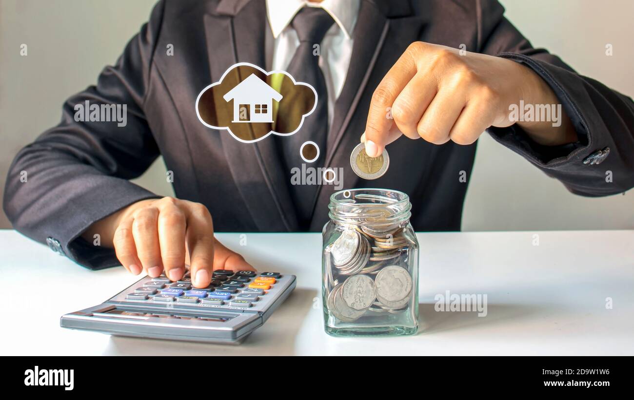 Uomo d'affari che mette i soldi in un vaso di risparmio, idea di risparmio di denaro per comprare una casa. Foto Stock