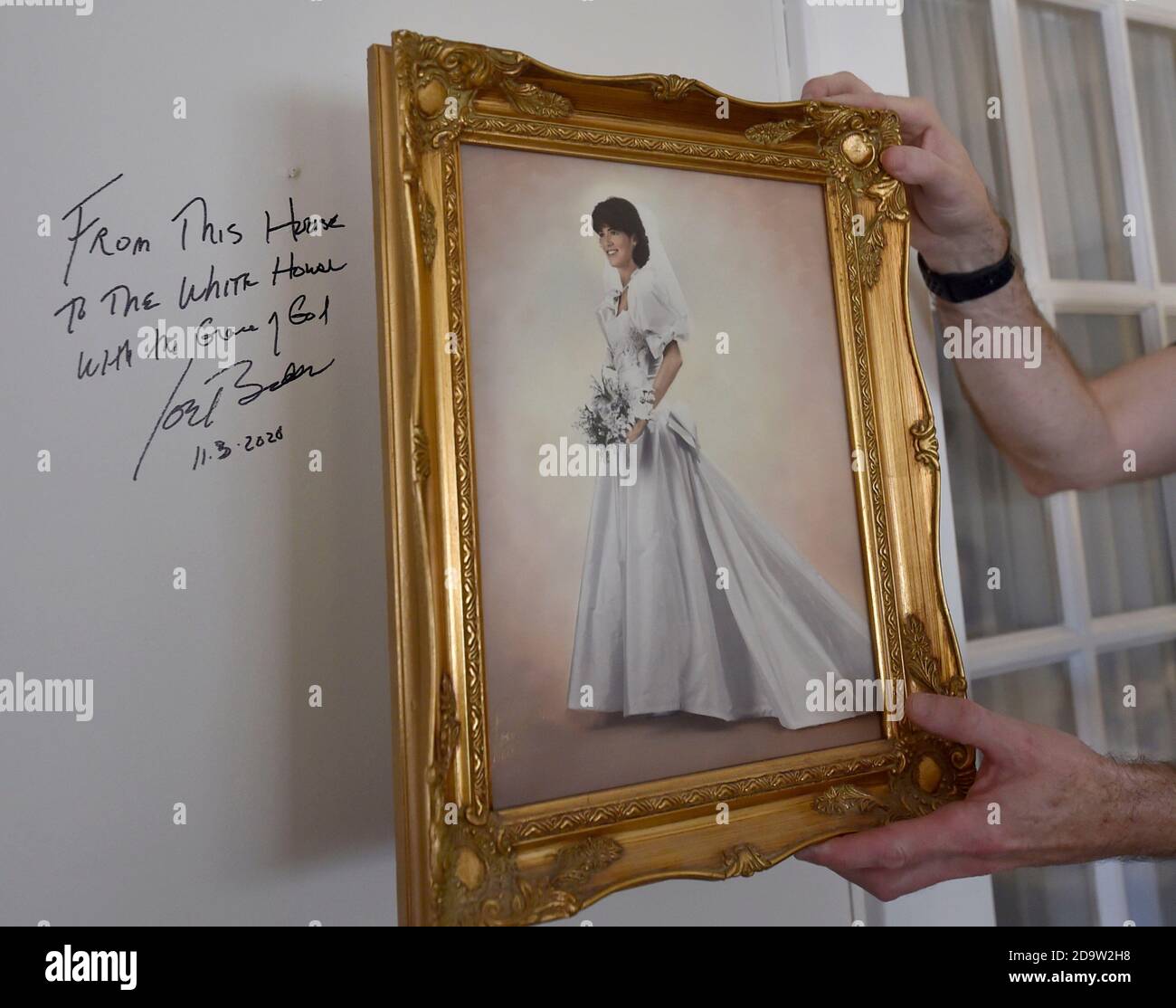 Chris Kearns rimuove una foto di matrimonio dalla parete del salotto delle sue famiglie per rivelare un punto in cui Joe Biden scrisse dicendo da questa Casa alla Casa Bianca con la Grazia di Dio.Joe Biden è nato e cresciuto a Scranton, Lunedì visitò la sua casa d'infanzia e lasciò un messaggio sulla parete della camera di famiglia. I sostenitori sono venuti a casa a North Washington Street a Scranton dopo che Biden ha vinto le elezioni, un flusso costante di automobili che si guidano piangendo, salutando e ballando fuori casa sua. Foto Stock