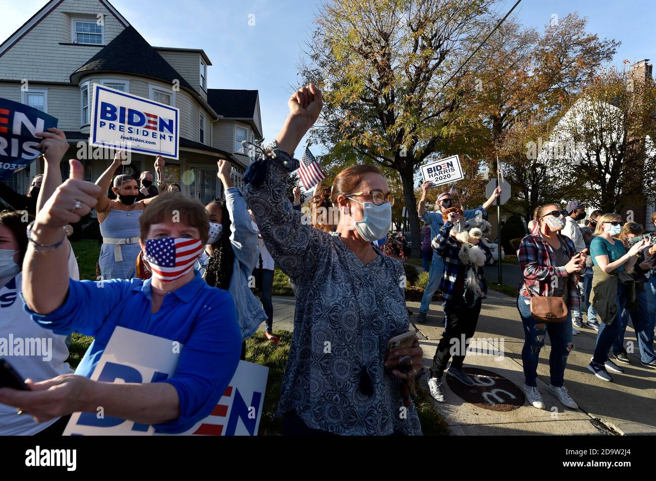 Le persone che indossano maschere celebrano l'elezione di Joe Biden al presidente fuori della sua casa d'infanzia a Scranton.Joe Biden è nato e cresciuto a Scranton, il lunedì ha visitato la sua casa d'infanzia e ha lasciato un messaggio sulla parete della camera di famiglia. I sostenitori sono venuti a casa a North Washington Street a Scranton dopo che Biden ha vinto le elezioni, un flusso costante di automobili che si guidano piangendo, salutando e ballando fuori casa sua. Foto Stock
