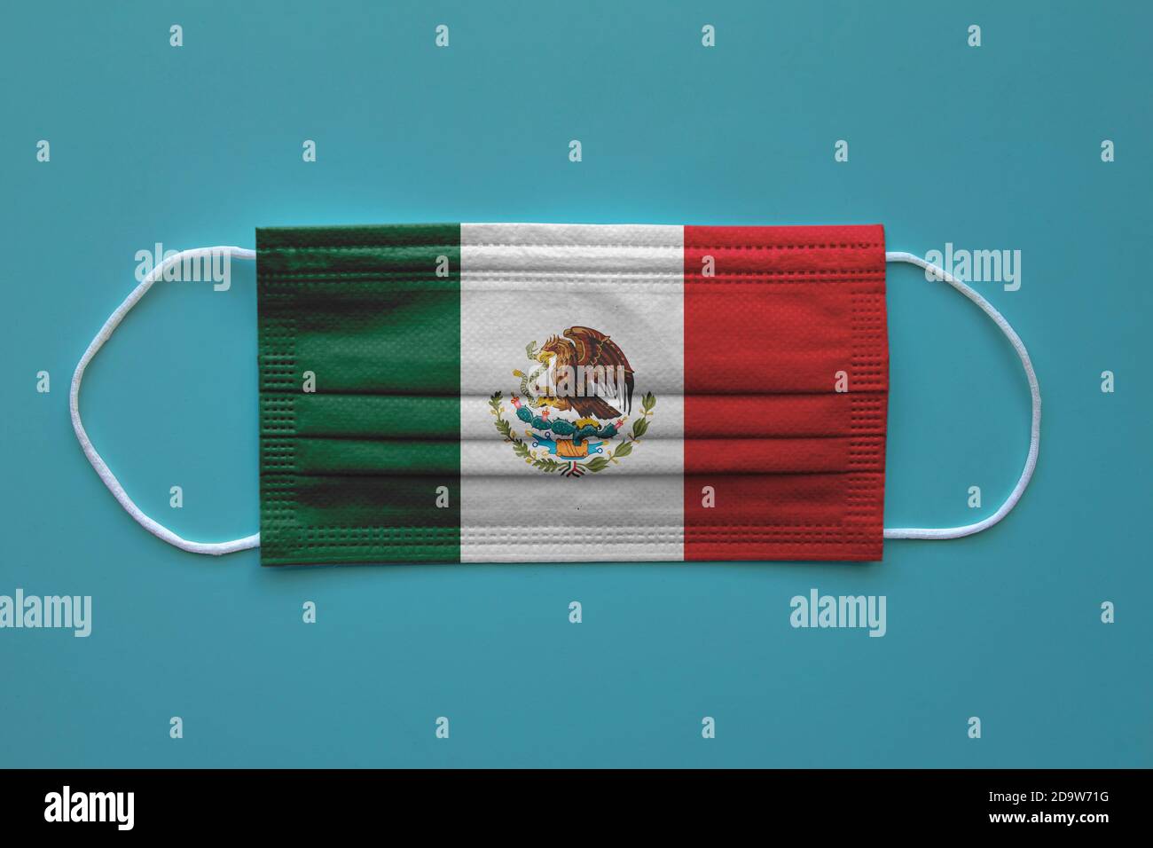 Una maschera facciale con una bandiera messicana su uno sfondo chiaro. Concetto: Messico durante una pandemia, covid-19, coronavirus. Foto Stock