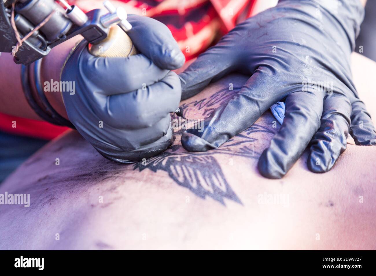 Primo piano del disegno di innesto del tatuaggio sul corpo utilizzando gli strumenti Foto Stock