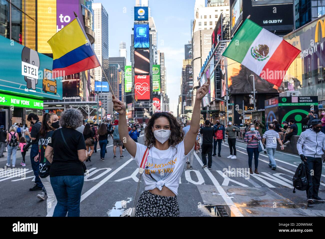 New York, Stati Uniti. 07 novembre 2020. Donna con bandiere messicane e colombiane celebra la vittoria di elezione del biglietto di Biden/Harris a Times Square. La gente è scese in strada in massa dopo che molti dei principali media hanno chiamato l'elezione per l'ex vice presidente Joe Biden. Rapporto NYPD ci è una gamma di 500 - 900 persone radunate in Times Square. Gruppi simili si sono riuniti nelle strade della città e in tutto il paese. Credit: SOPA Images Limited/Alamy Live News Foto Stock