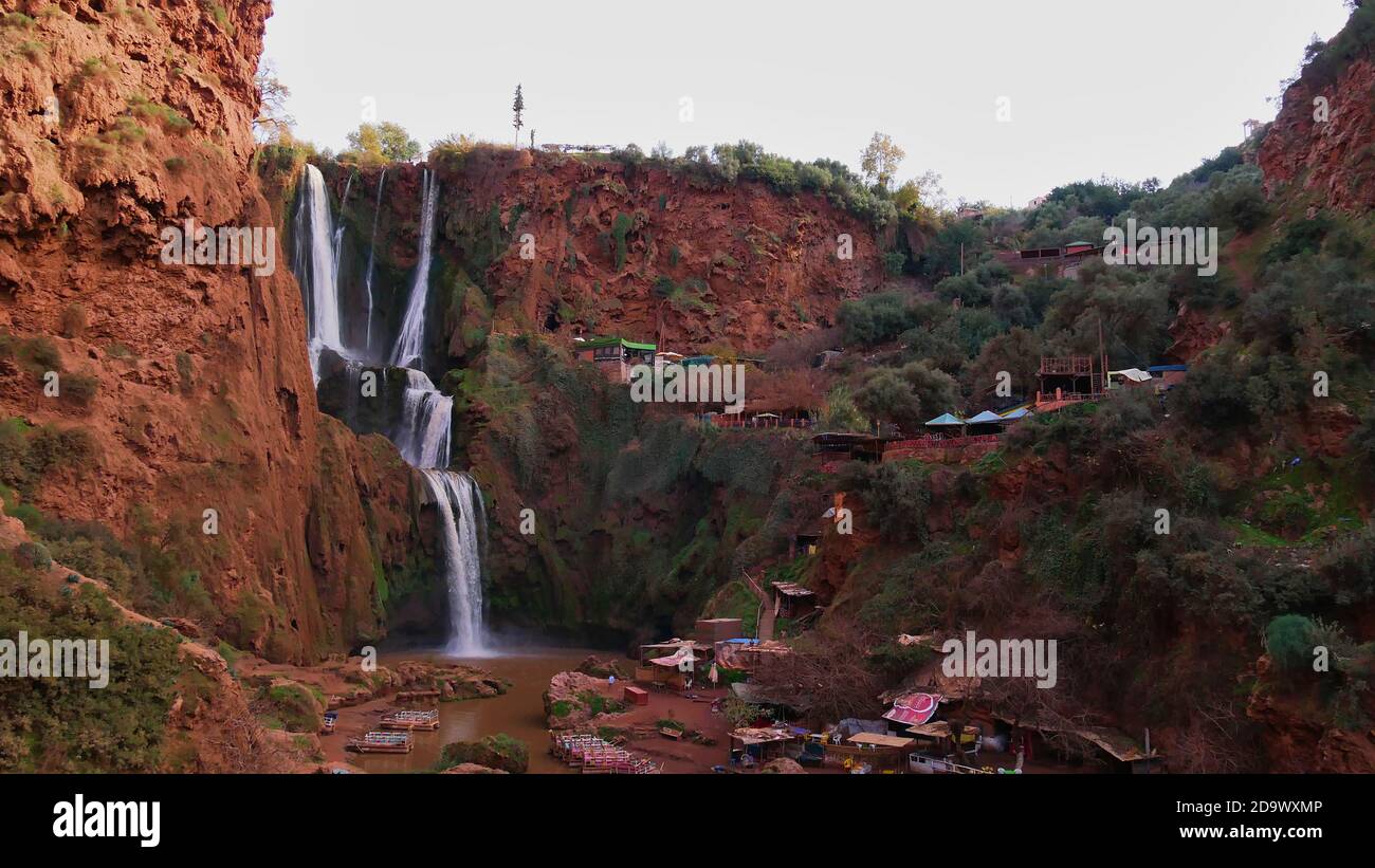 Vista panoramica delle famose cascate di Ouzoud (cascate d'acqua) situate in una gola nel villaggio di Ouzoud, Marocco con barche, negozi di souvenir per i turisti. Foto Stock
