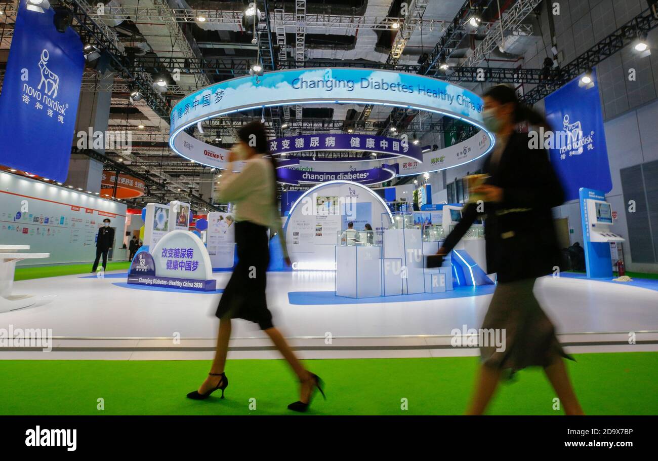 Shanghai, Cina. 7 Nov 2020. I visitatori camminano oltre lo stand di Novo Nordisk all'area espositiva Medical Equipment and Healthcare Products durante il terzo China International Import Expo (CIIE) a Shanghai, Cina orientale, 7 novembre 2020. Un numero significativo di società partecipa per tre anni consecutivi alla CIIE. Credit: Zhang Yuwei/Xinhua/Alamy Live News Foto Stock
