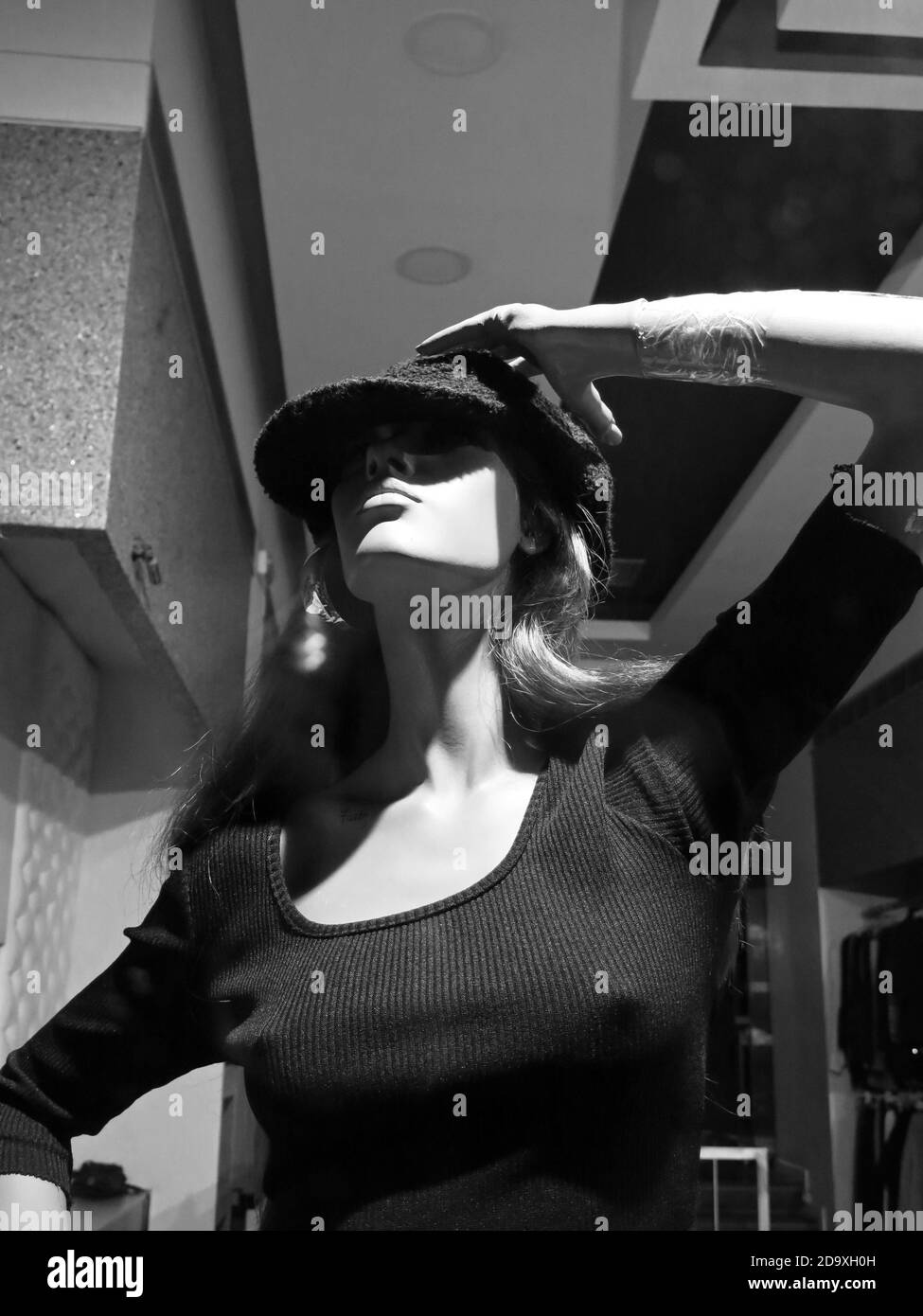 Manichetta femminile vestita con top blu scuro, con cappello. Concetto: Vendita al dettaglio. Foto Stock