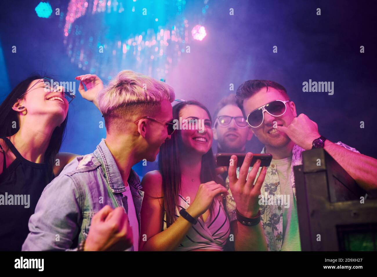 I giovani sniffing la droga in nightclub con le luci laser colorate Foto Stock