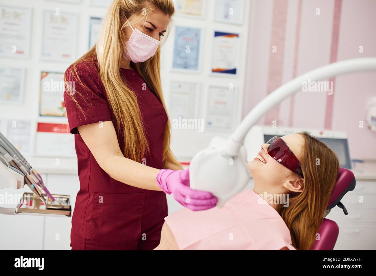 Bambina in occhiali protettivi in visita dentista in clinica. Concezione di stomatologia Foto Stock