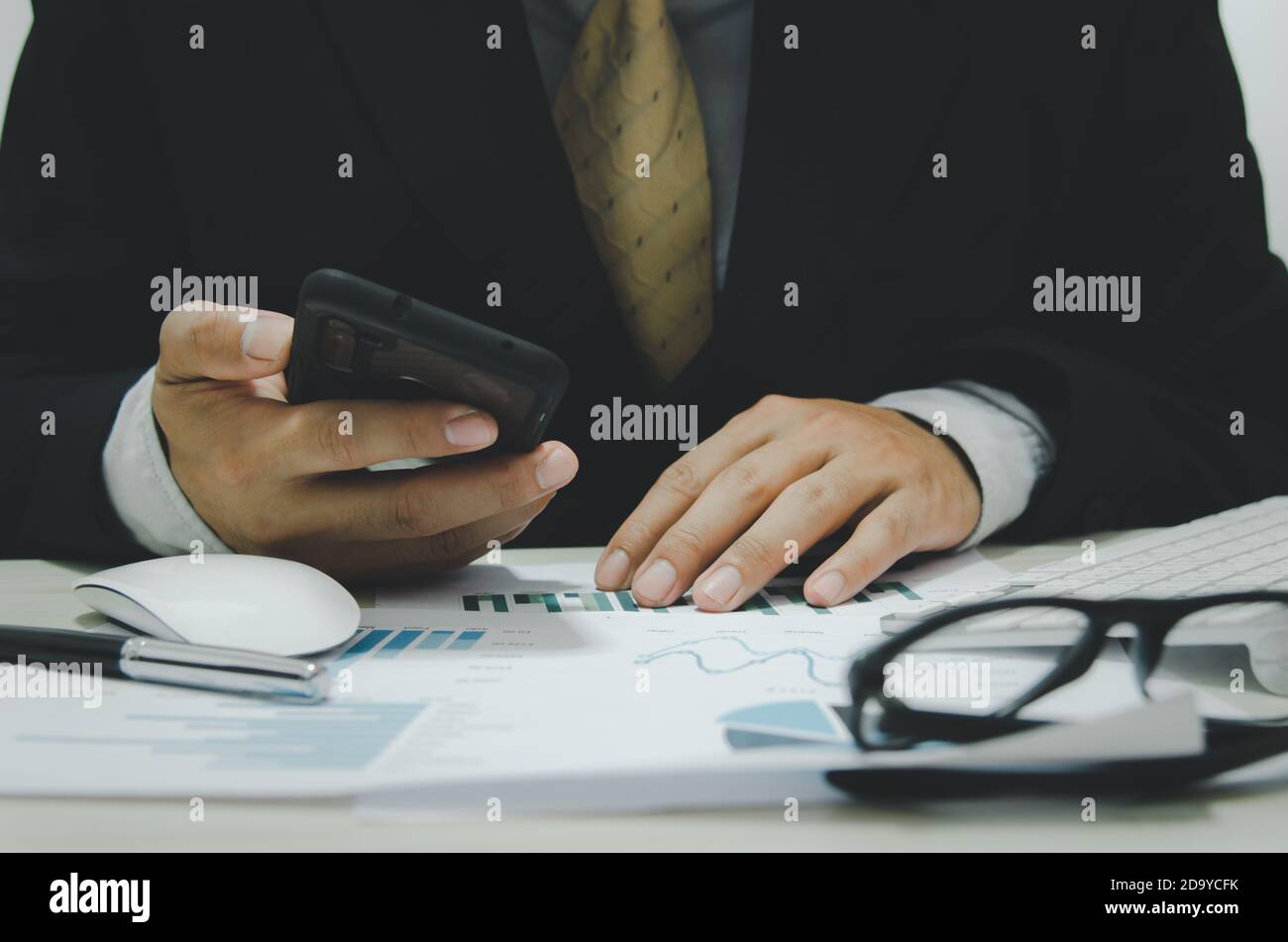 Documenti aziendali grafici e grafici del bilancio e del profitto Crescita tenere un telefono cellulare alla scrivania.Business Concept tecnologia Foto Stock
