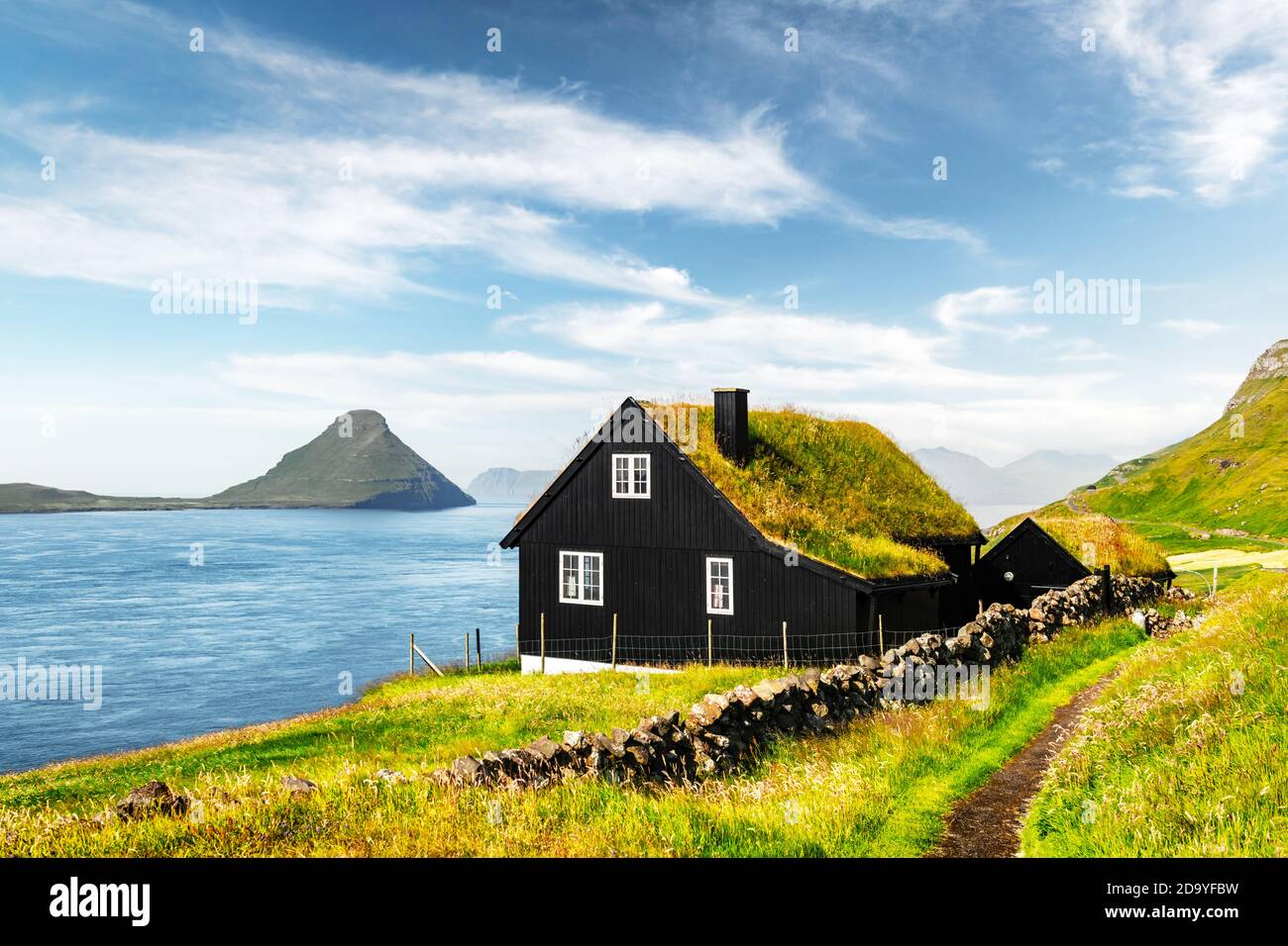 Mattinata nebbiosa vista di una casa con il tipico turf-top tetto di erba nel villaggio Velbastadur sull isola di Streymoy, isole Faerøer, Danimarca. Fotografia di paesaggi Foto Stock
