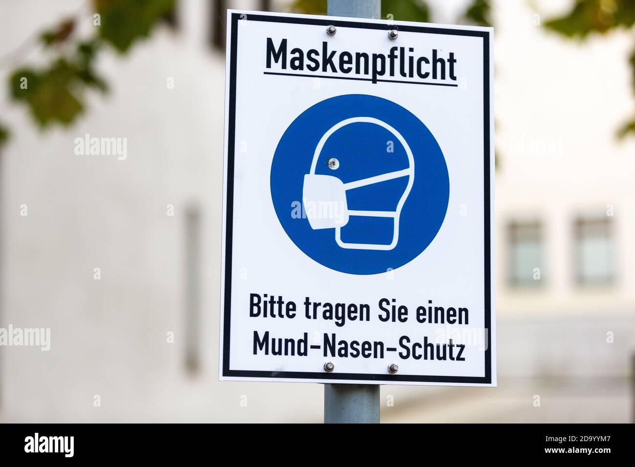 Info sign in una città tedesca con testo tedesco. Maskenpflicht, Bitte tragen Sie einen Mund-Nasen-Schutz. Maschera obbligatoria, si prega di indossare la bocca e il naso prott Foto Stock