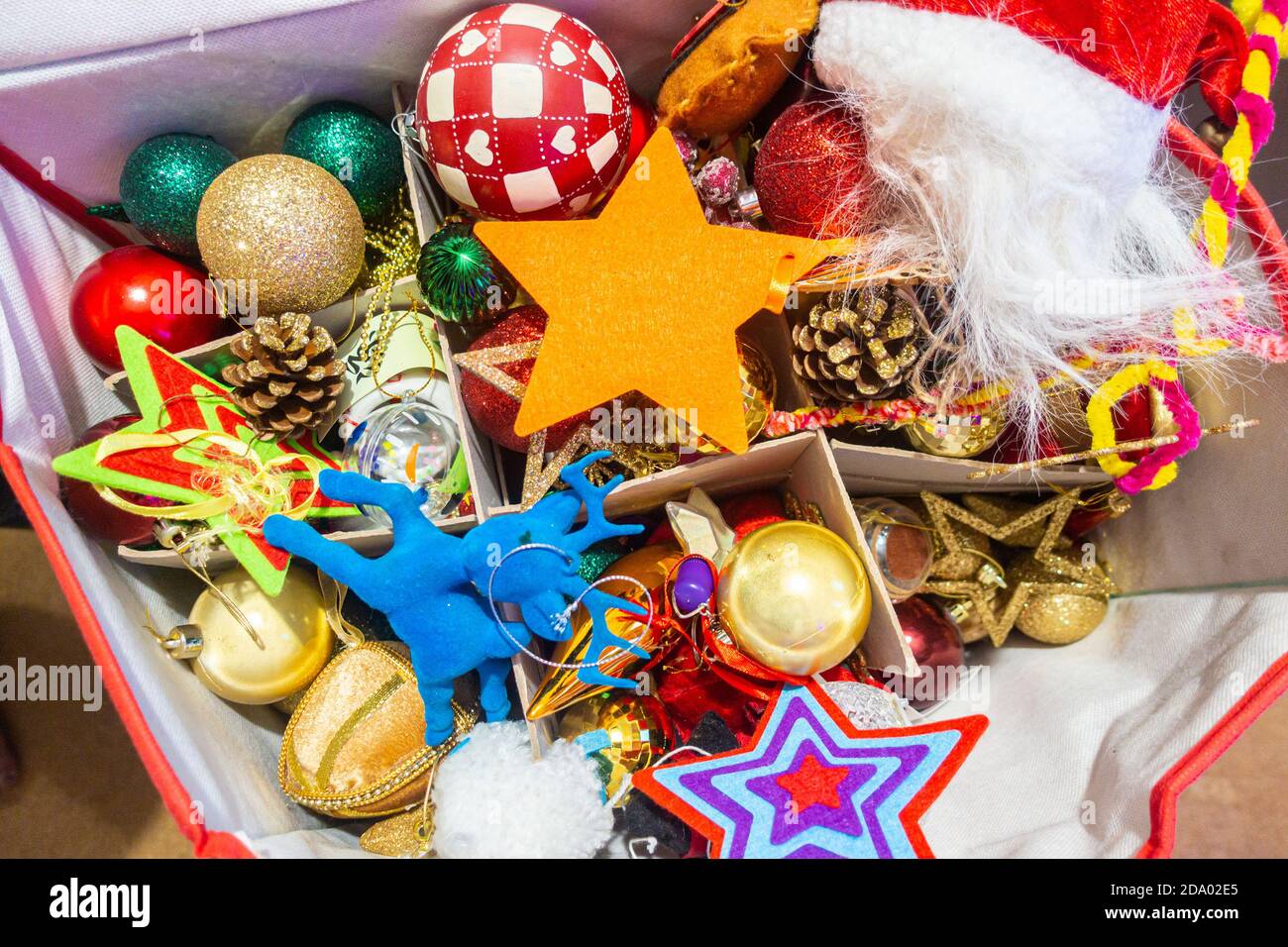 Una scatola piena di baubles e decorazioni natalizie colorate per Un albero di Natale Foto Stock