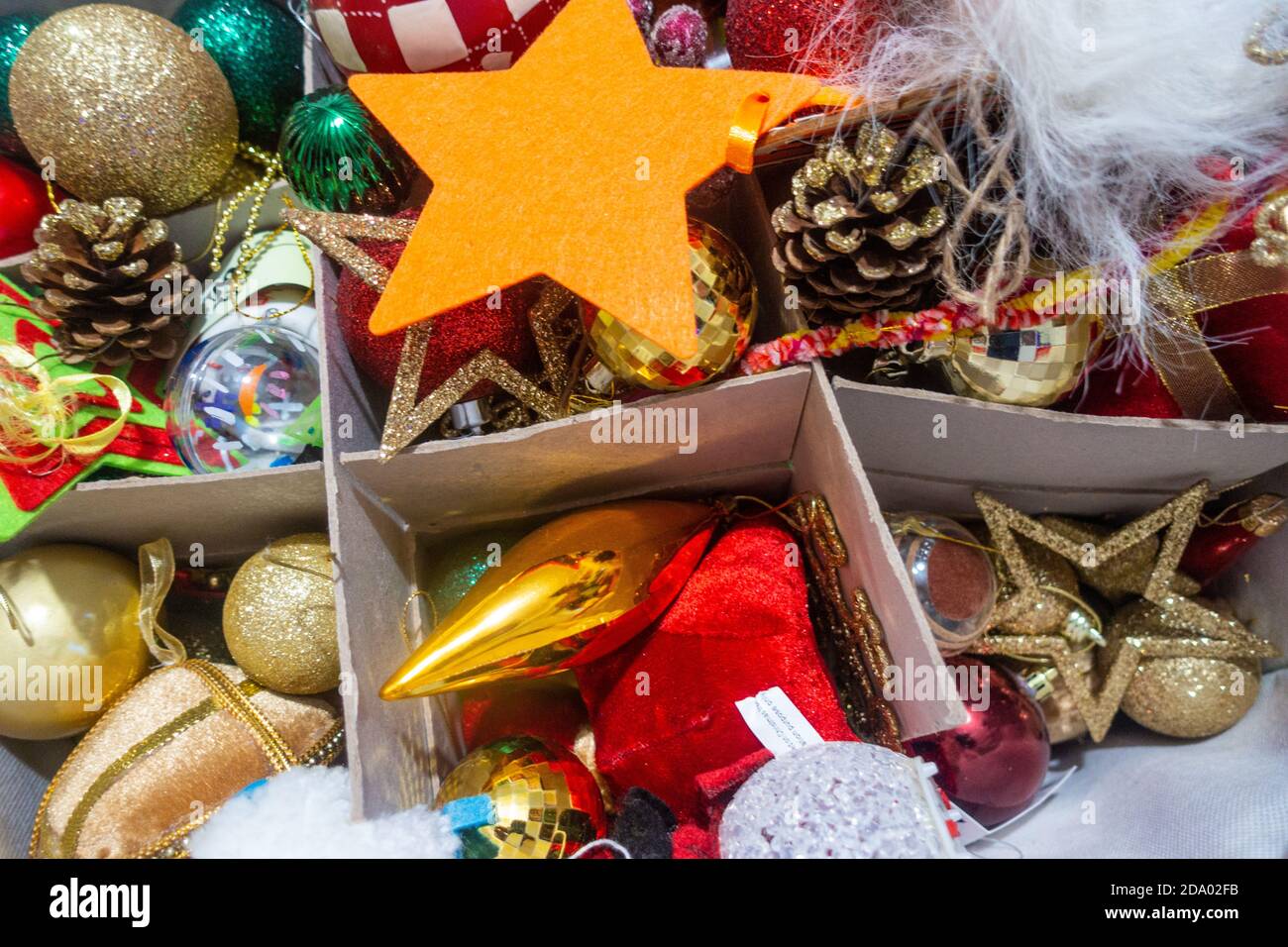 Una scatola piena di baubles e decorazioni natalizie colorate per Un albero di Natale Foto Stock
