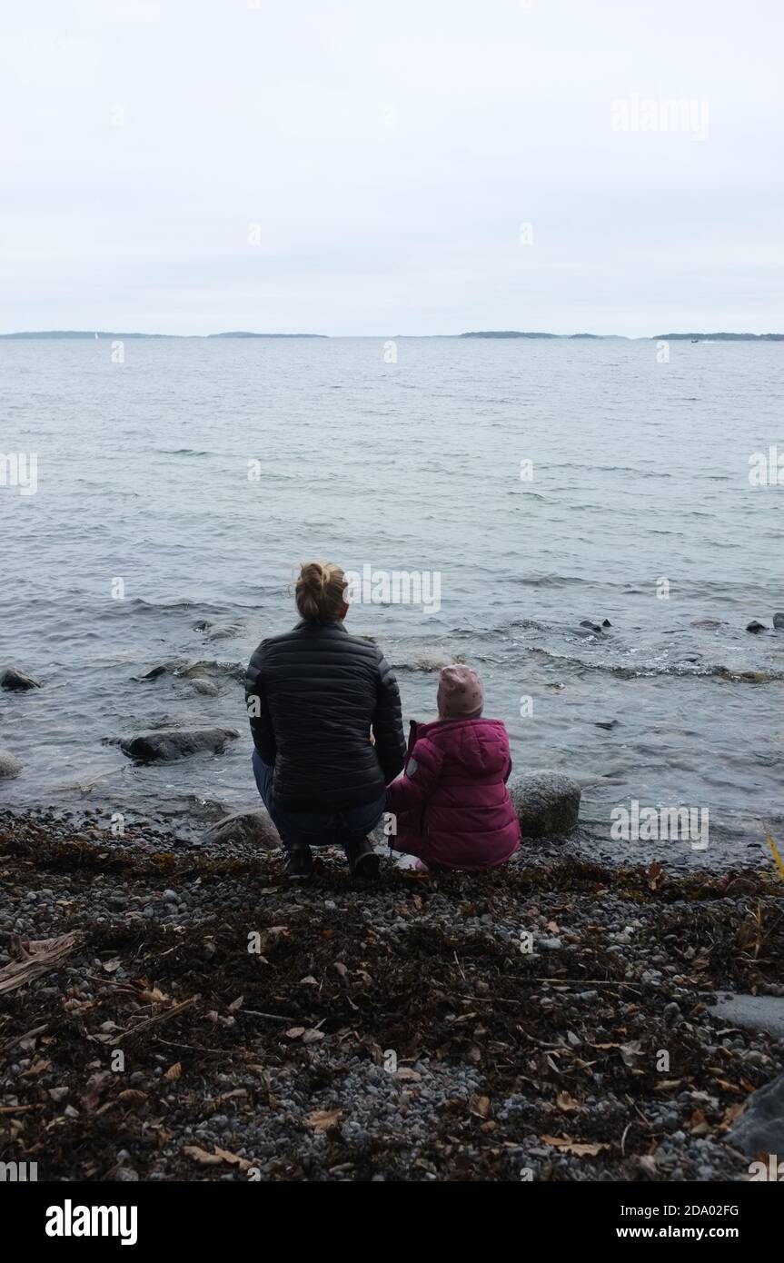 Madre e figlia che guardano il mare. Värmdö, Stoccolma. L'Arcipelago sullo sfondo. Foto Stock