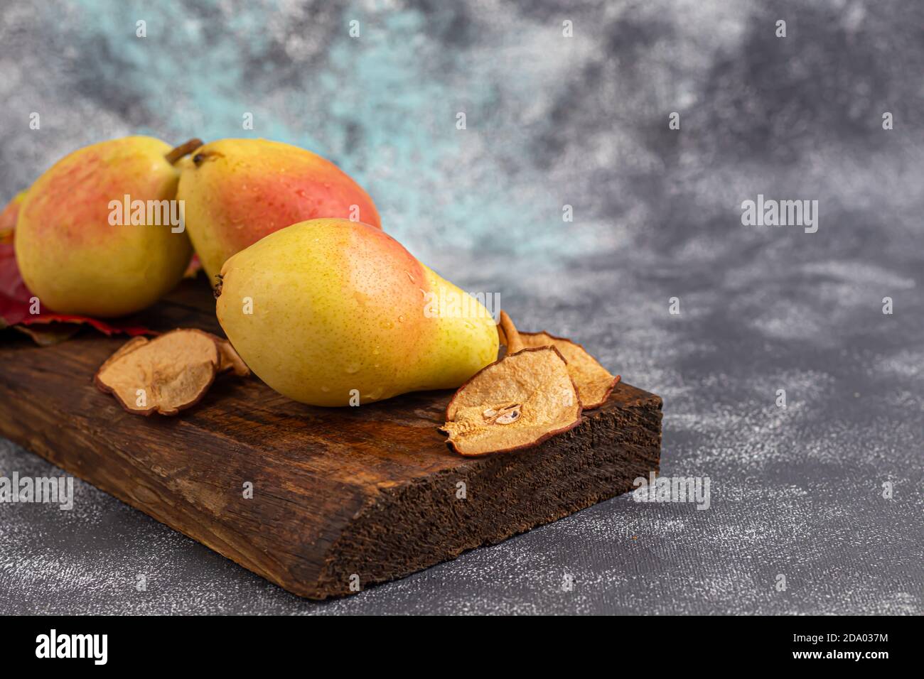 Pere su uno sfondo chiaro. Concetto autunnale. Nelle vicinanze si trovano patatine e noci di pera secca. Spazio di copia. Foto Stock