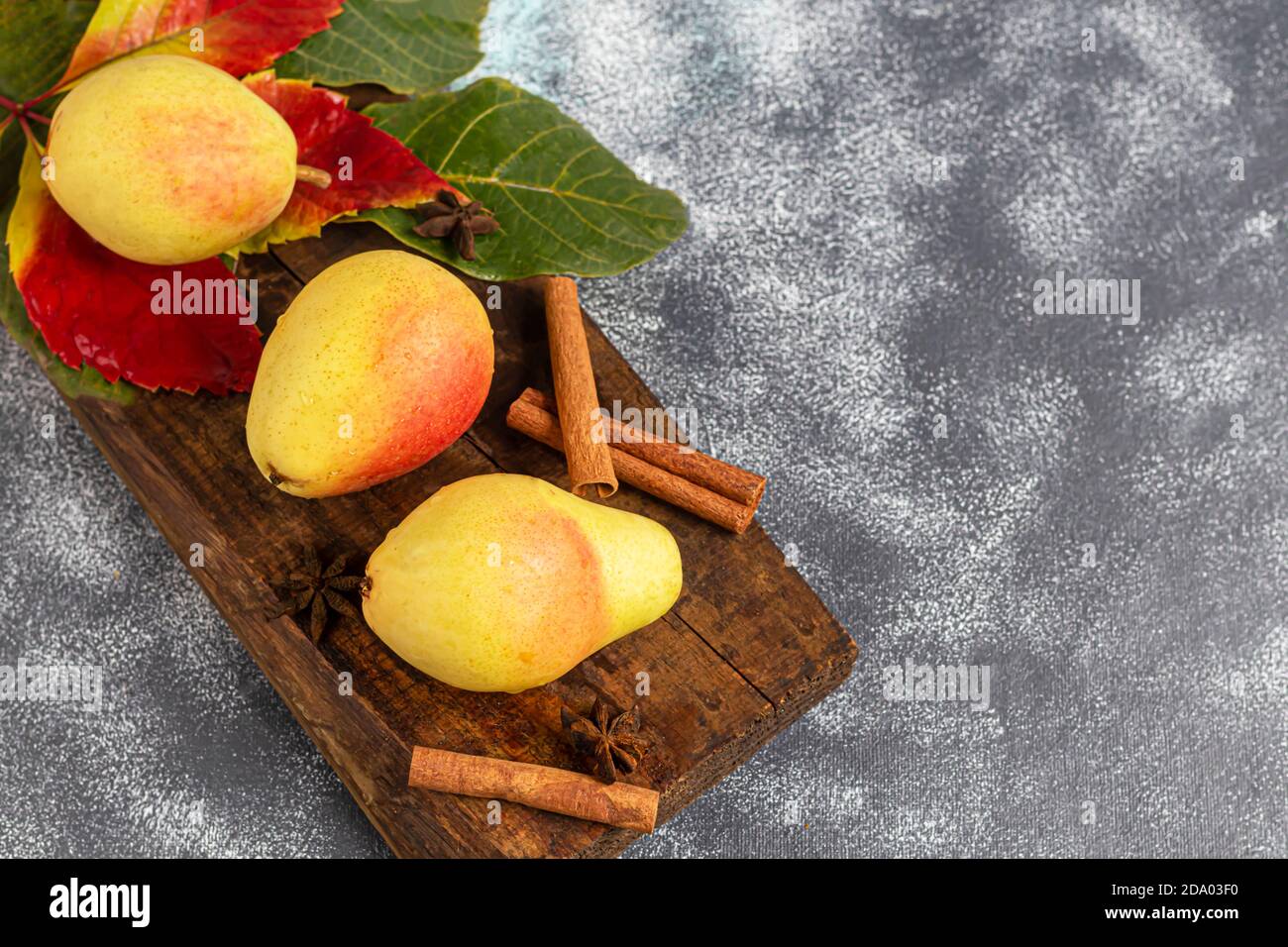 Pere su uno sfondo chiaro. Concetto autunnale. Nelle vicinanze si trovano patatine e noci di pera secca. Spazio di copia. Foto Stock